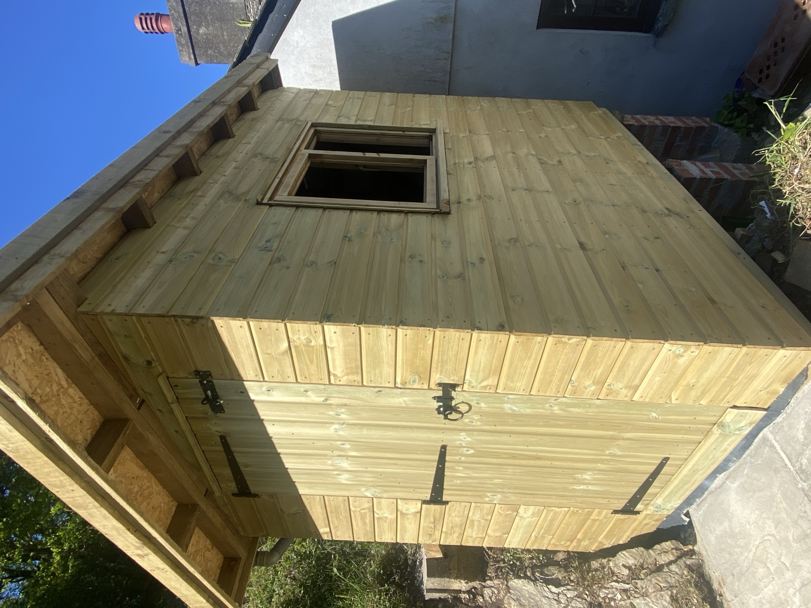 Timber-clad outbuilding with a side window