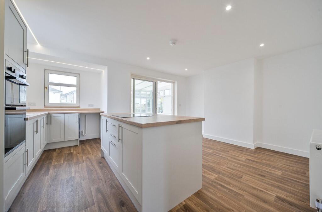 Completed open-plan kitchen with an island and new flooring