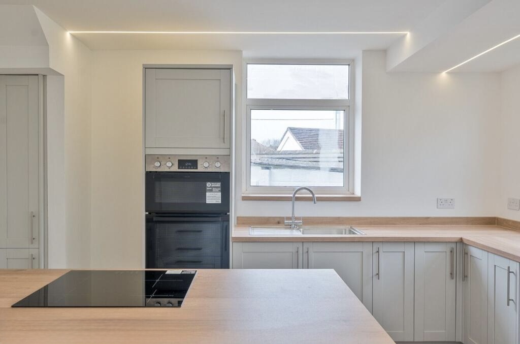 Shaker kitchen cabinetry, wood-effect worktops and integrated ovens