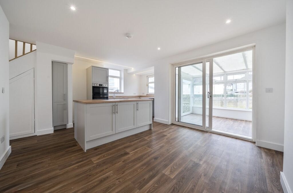 Open-plan living space after the knock-through, plastering, painting and flooring